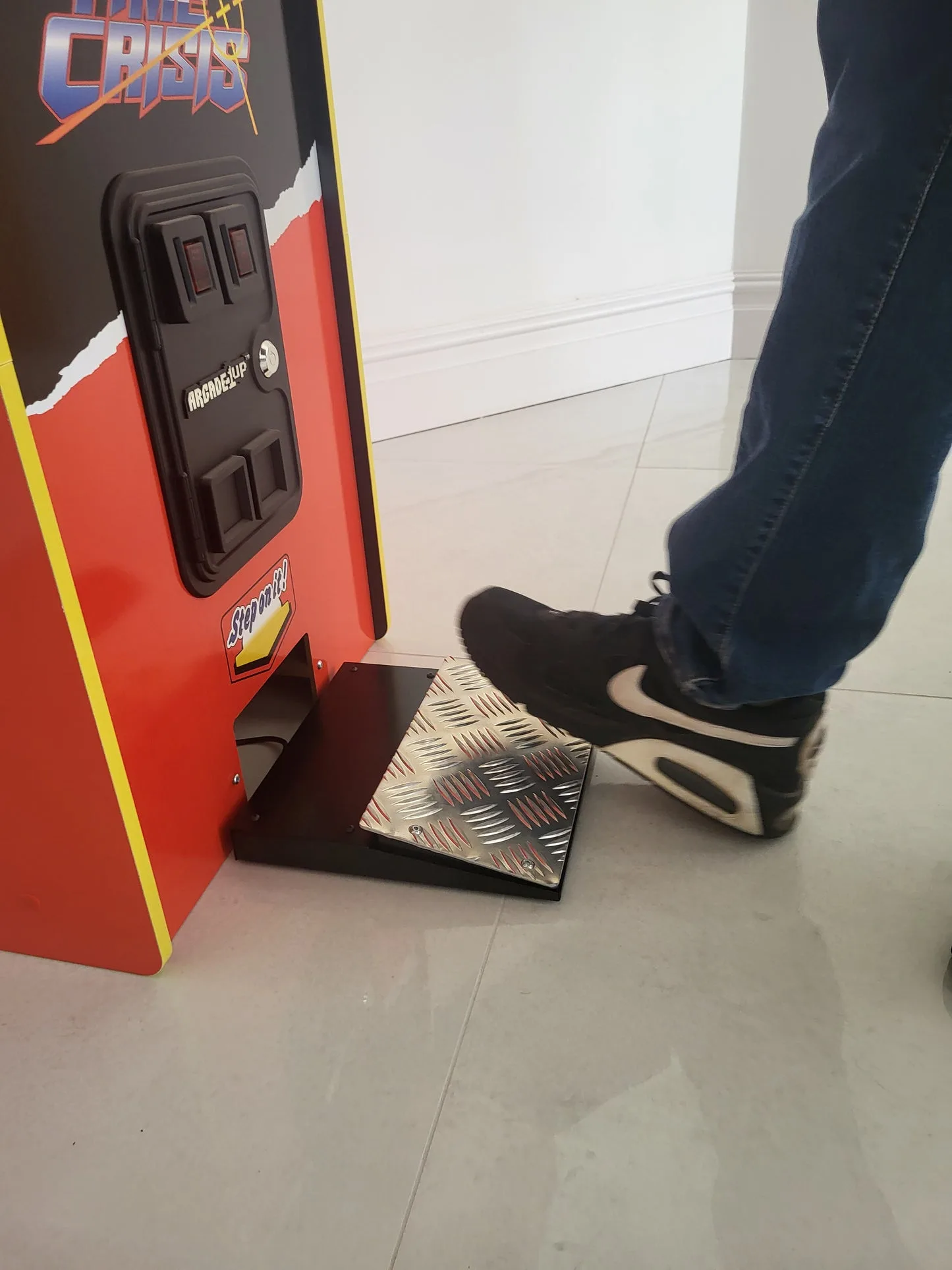 Pedal de um fliperama visto de perto ao lado da cabine.